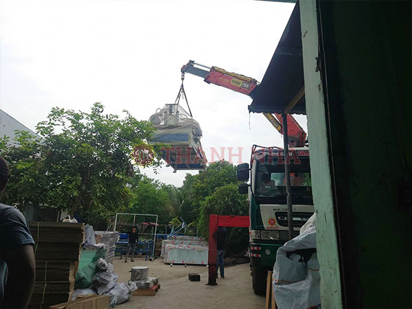 Xe nâng cẩu đang chất máy móc xuống khỏi thùng xe