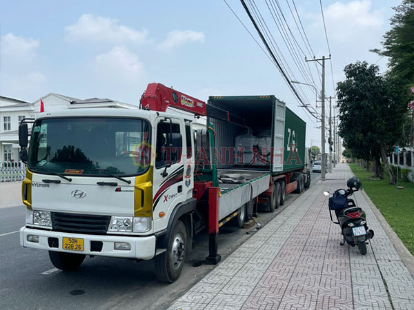 Xe nâng cẩu đang hỗ trợ lấy hàng ra từ thùng công