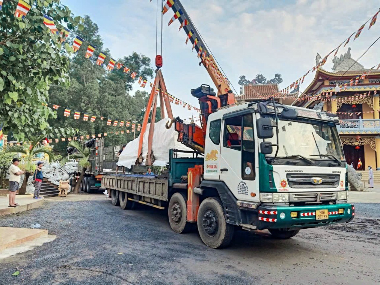 Hình ảnh xe cẩu đang hỗ trợ vận chuyển tượng Phật cho Chùa 